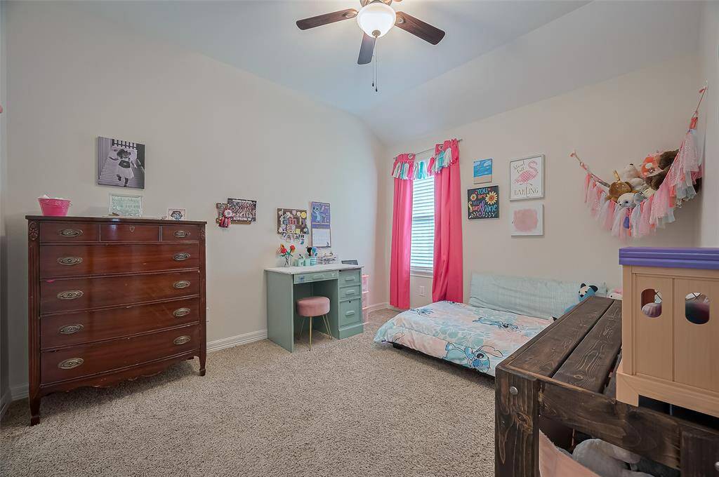 Secondary bedroom with carpet and stylish ceiling fan.