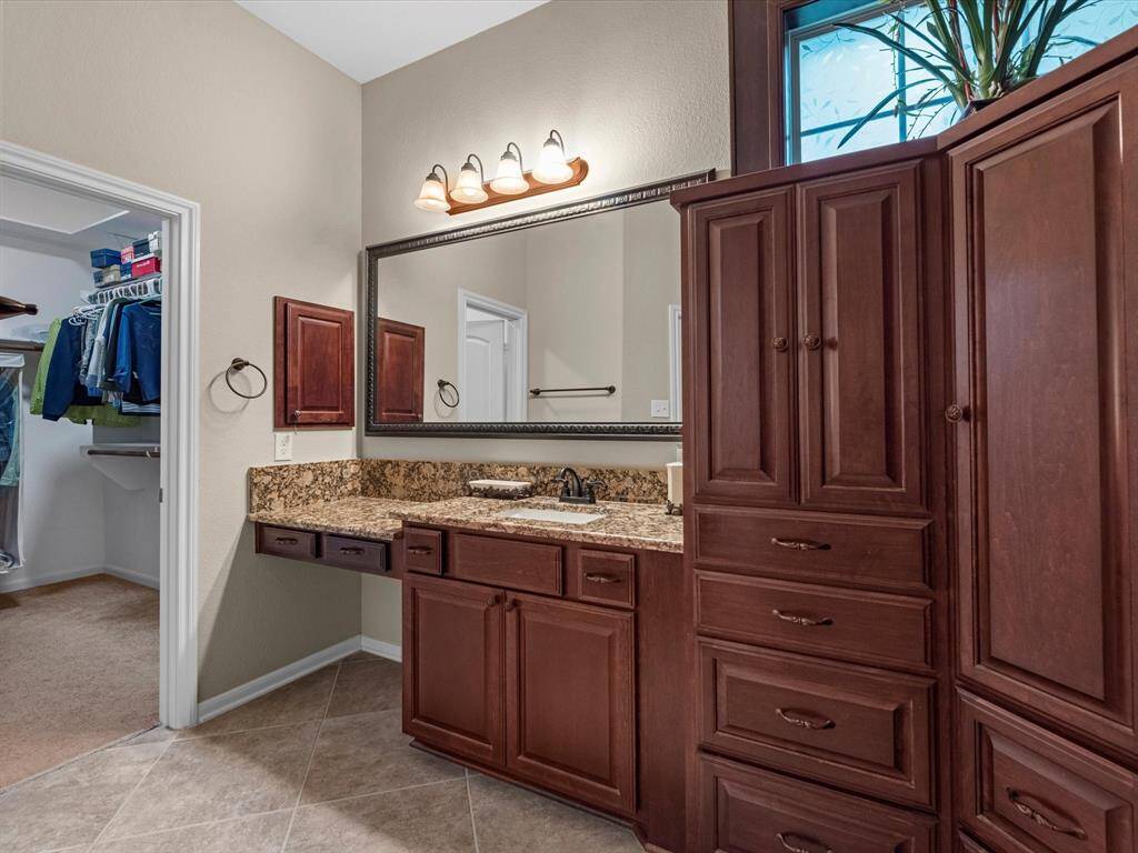 Vanity area, framed mirrors, and granite counters in the primary bath