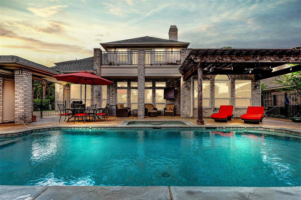 This stunning home features a spacious backyard with a sparkling pool, a cozy patio, and a pergola for shade. Perfect for outdoor entertaining and relaxation.