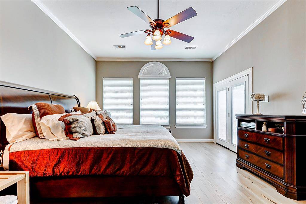 Experience luxury in this spacious primary bedroom with elegant French doors opening to a stunning backyard.