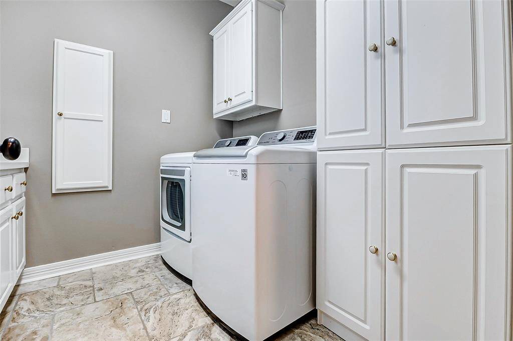 Spacious laundry room with ample storage cabinets.