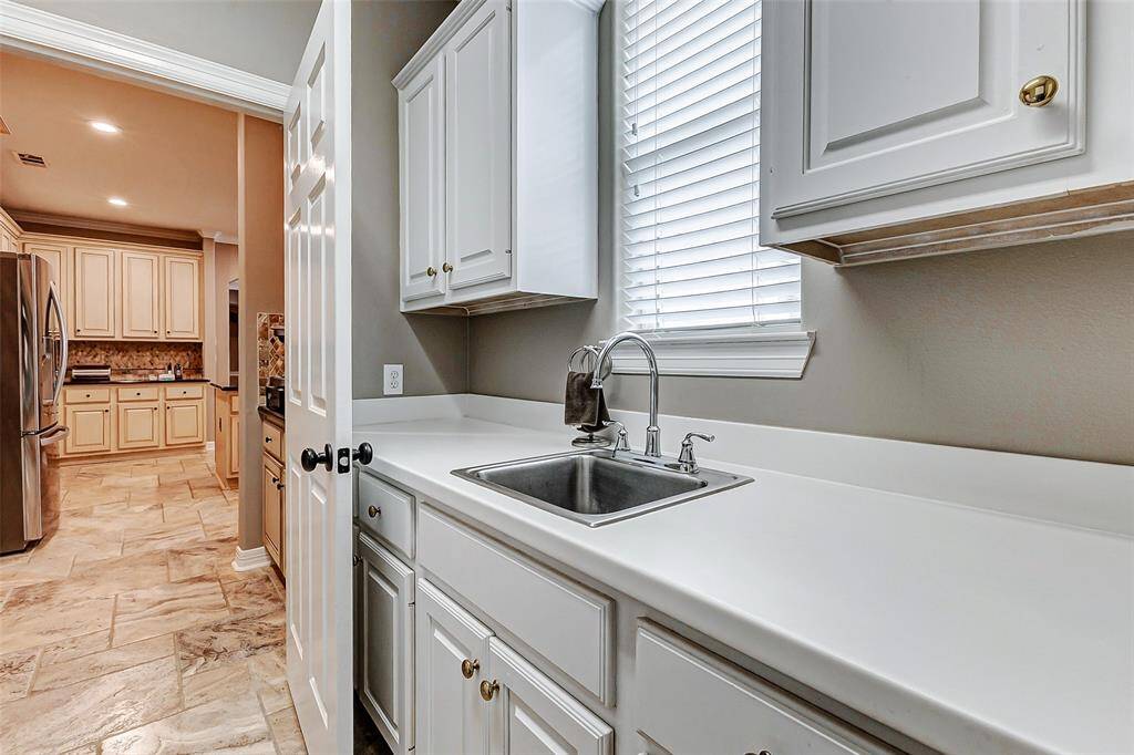 Efficient laundry room featuring abundant storage, a convenient sink, and generous counter space.