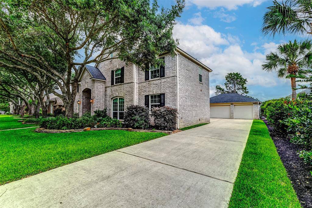 Expansive driveway leading to a spacious three-car garage.