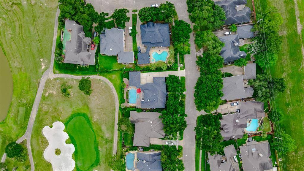 Aerial view showcasing the home's prime location with lush surroundings and close proximity to the golf course.