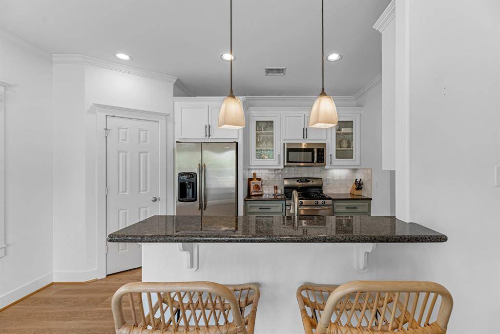 Area for bar stools at the kitchen sink space. Note the glass front cabinets