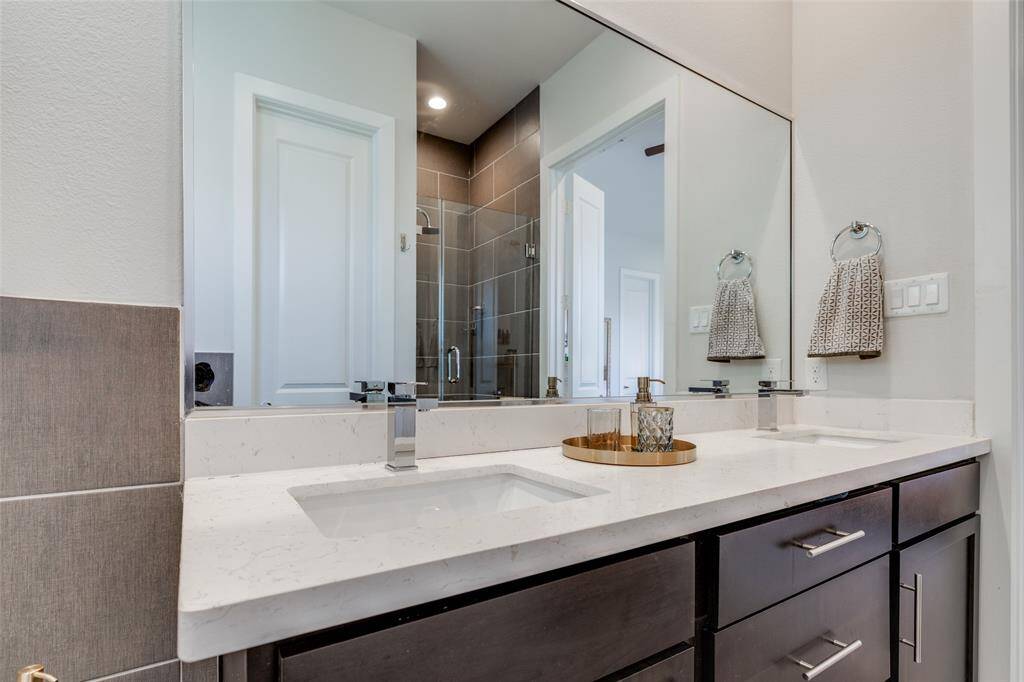 Gorgeous Primary Bathroom with stand alone tube, gray tile floor & shower, beautiful mahogany cabinets, 2 sinks , los of natural light & high ceilings