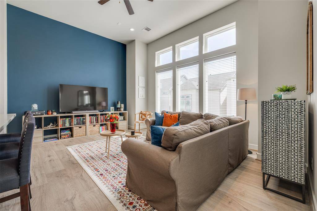 Enjoy watching TV in the open plan living room, lots of natural light from the wall of windows, high ceiling, recessed lighting