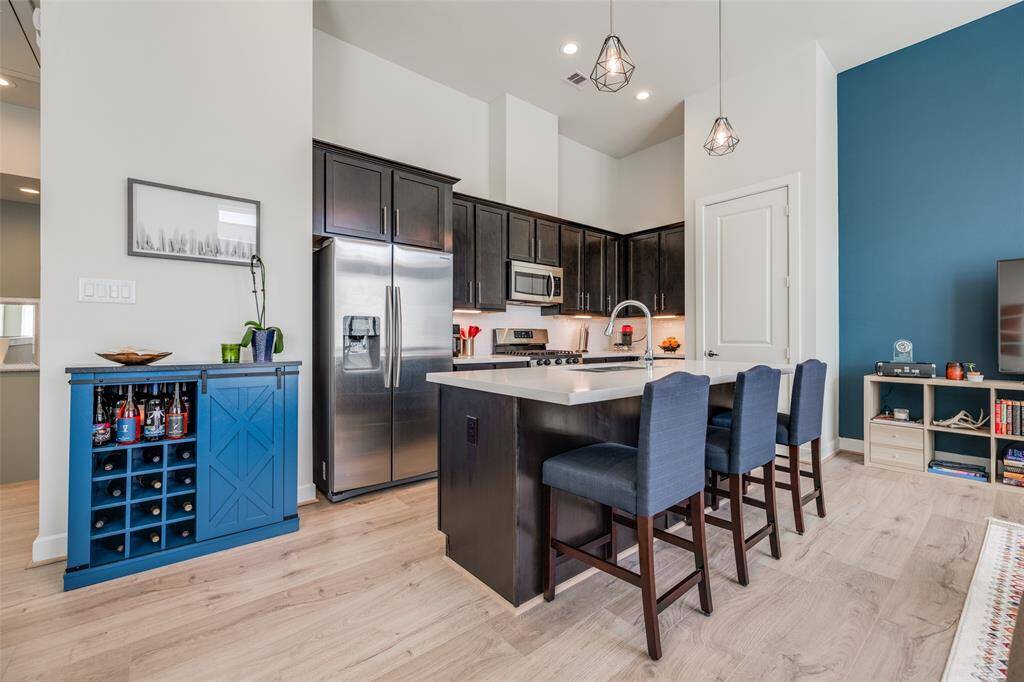 Enjoy entertaining family & friends in this modern kitchen with lots of cabinets, pantry, SS appliances, gorgeous quartz counters &  space for bar stools