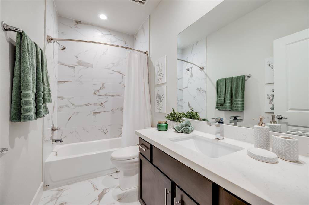 Shared Bathroom with beautiful Quartz Counters, dark cabinets & beautiful porcelain tile