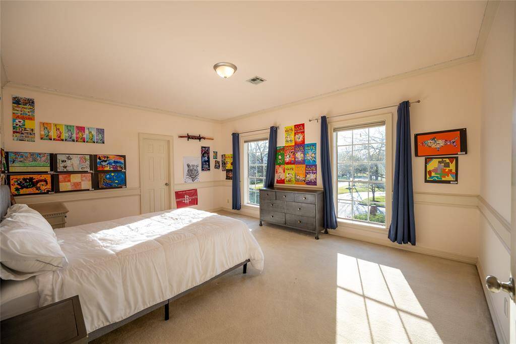 This vibrant and spacious bedroom is filled with natural light streaming through large windows.