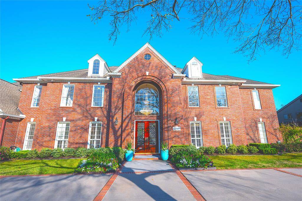 The expansive windows flood the home with natural light, highlighting their elegant design and enhancing the home’s grand entrance.