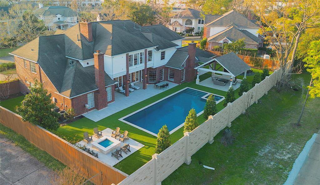 This stunning backyard offers an unparalleled blend of luxury and privacy, featuring a resort-style pool, lush greenery, and mature trees that create a serene, natural ambiance.