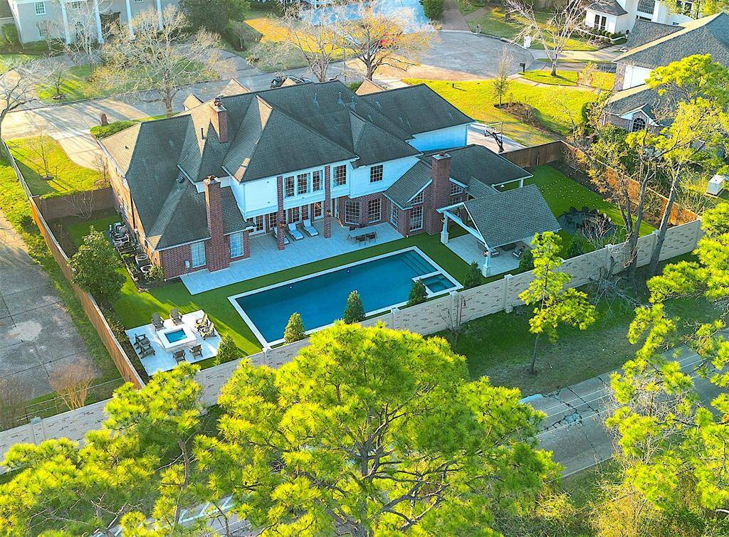 This expansive backyard retreat features a luxurious pool, lush landscaping, and a well-appointed patio.