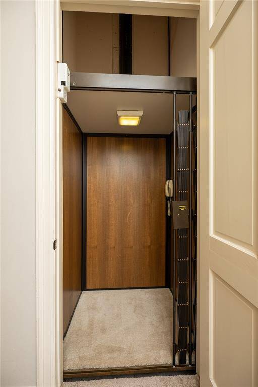This home features a private elevator with rich wood paneling and a secure accordion-style safety.