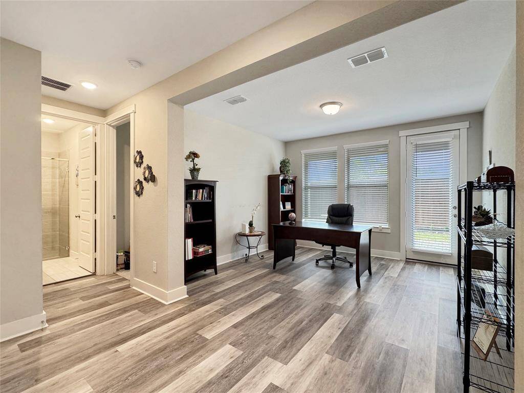 Bright home office with large windows and a glass door for natural light coming from the patio.