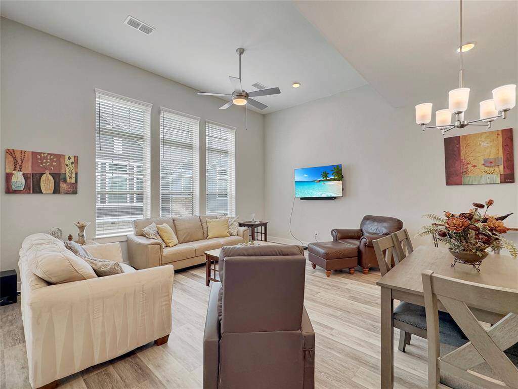 Bright and inviting living space with high ceilings and natural light from large windows, perfect for relaxation and entertainment.