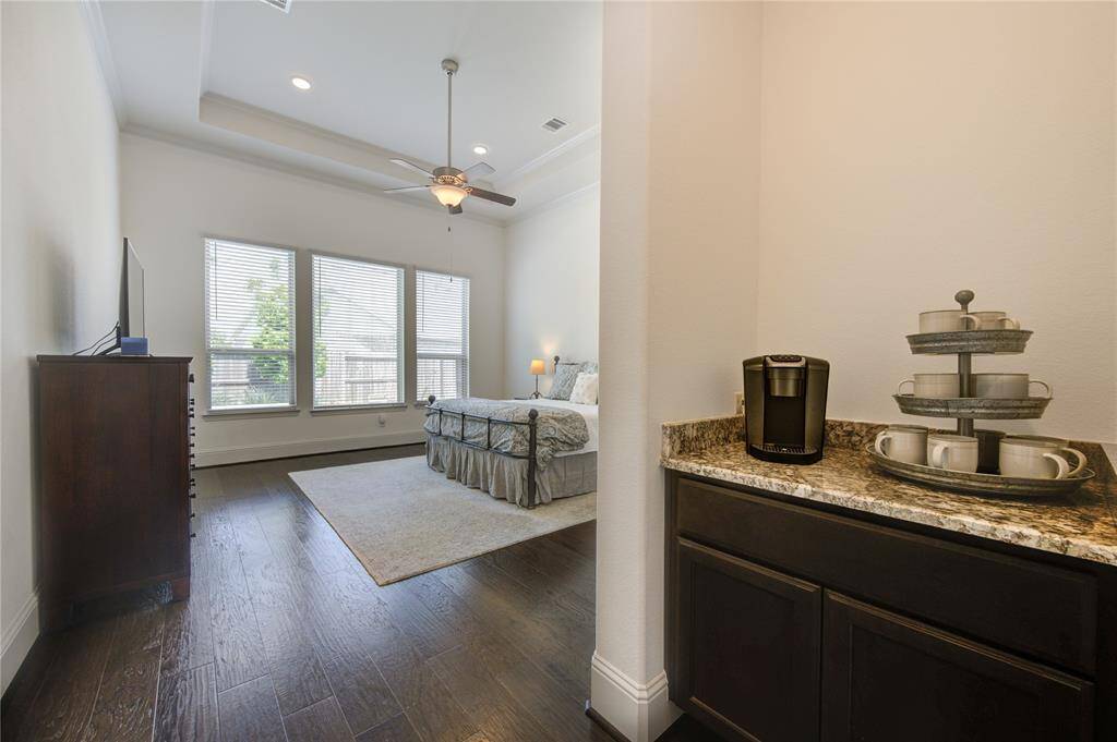 The primary bedroom features a cozy coffee station on a granite countertop, adding convenience and charm.