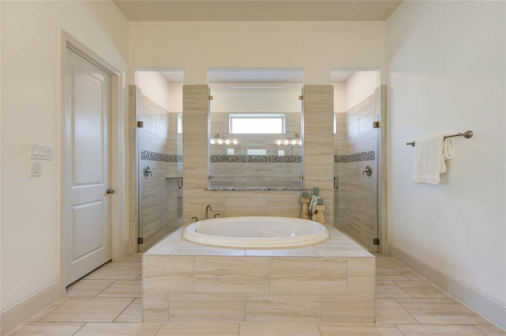 This neutral color palette and modern fixtures create a serene, spa-like atmosphere.