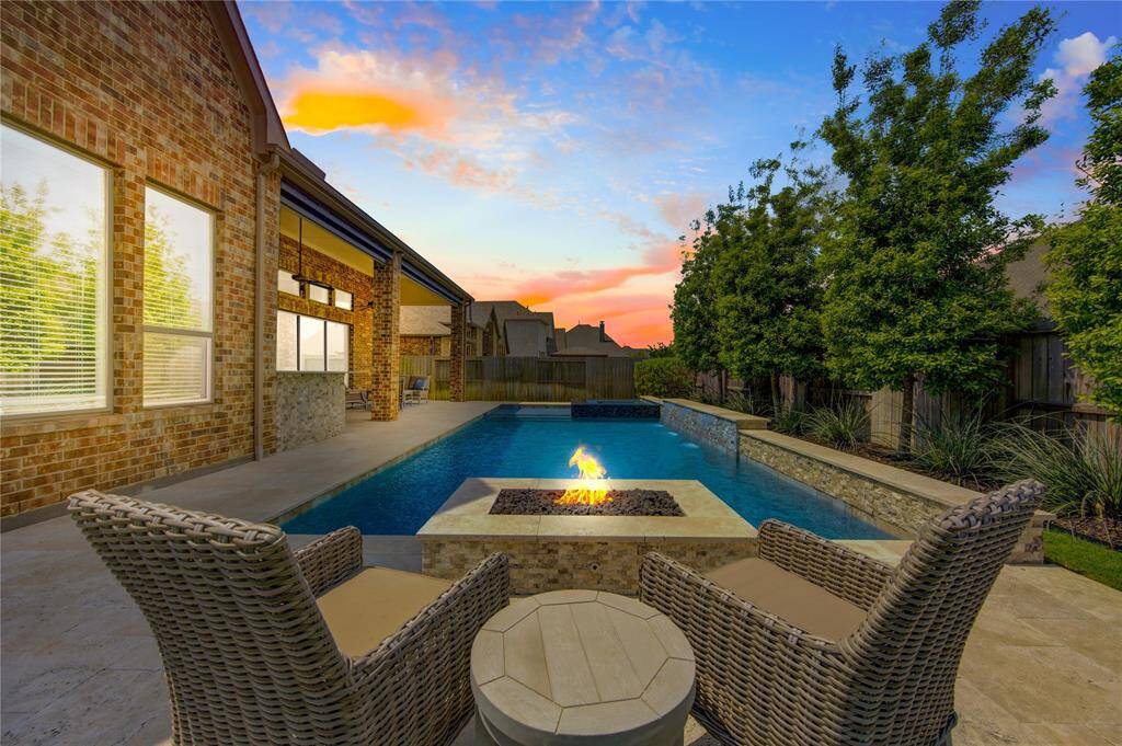 The beautiful backyard features a luxurious pool/spa and a fire pit surrounded by mature trees for privacy. Enjoy this relaxing outdoor oasis in the evenings after work.