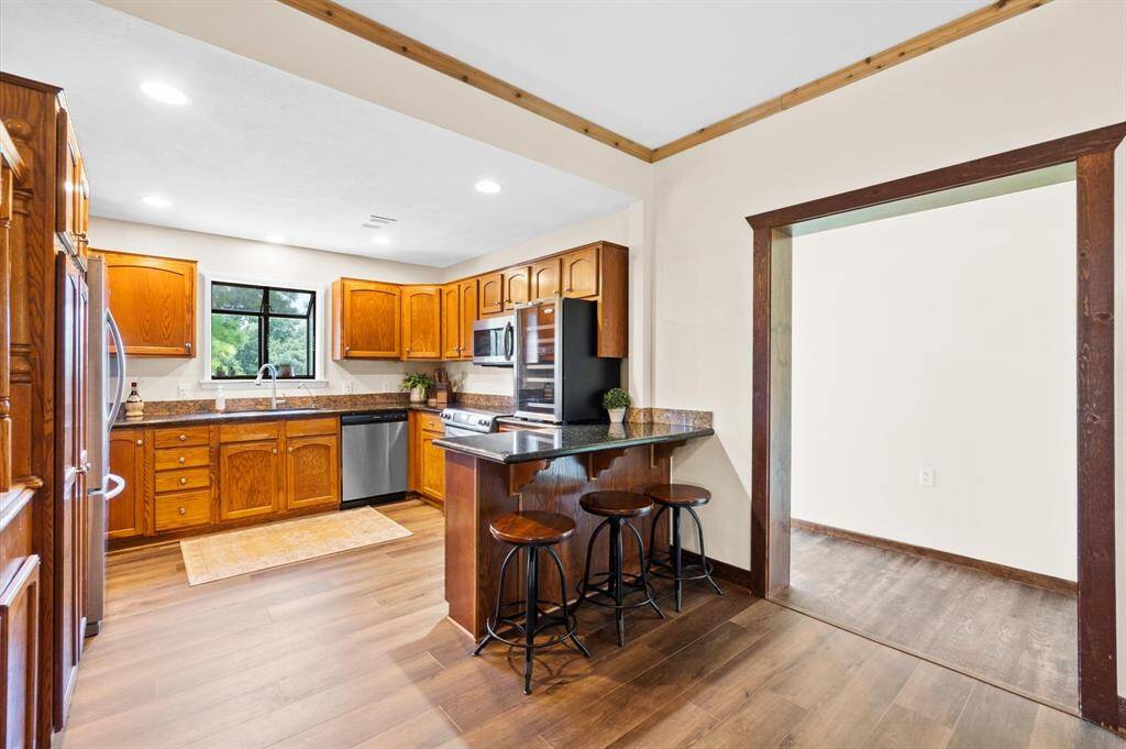 Kitchen with granite countertops, electric cooking and microwave.