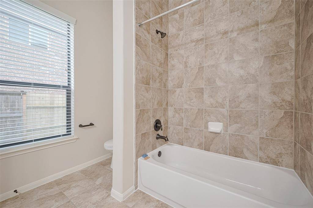 Shower/tub combo in secondary bath with beautiful tile detail