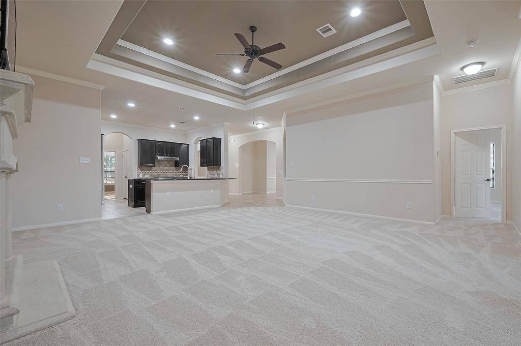 Open-concept and HUGE living room space with tray ceiling and recessed lighting