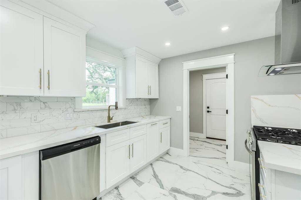 Kitchen with view toward laundry room and exit door to garage