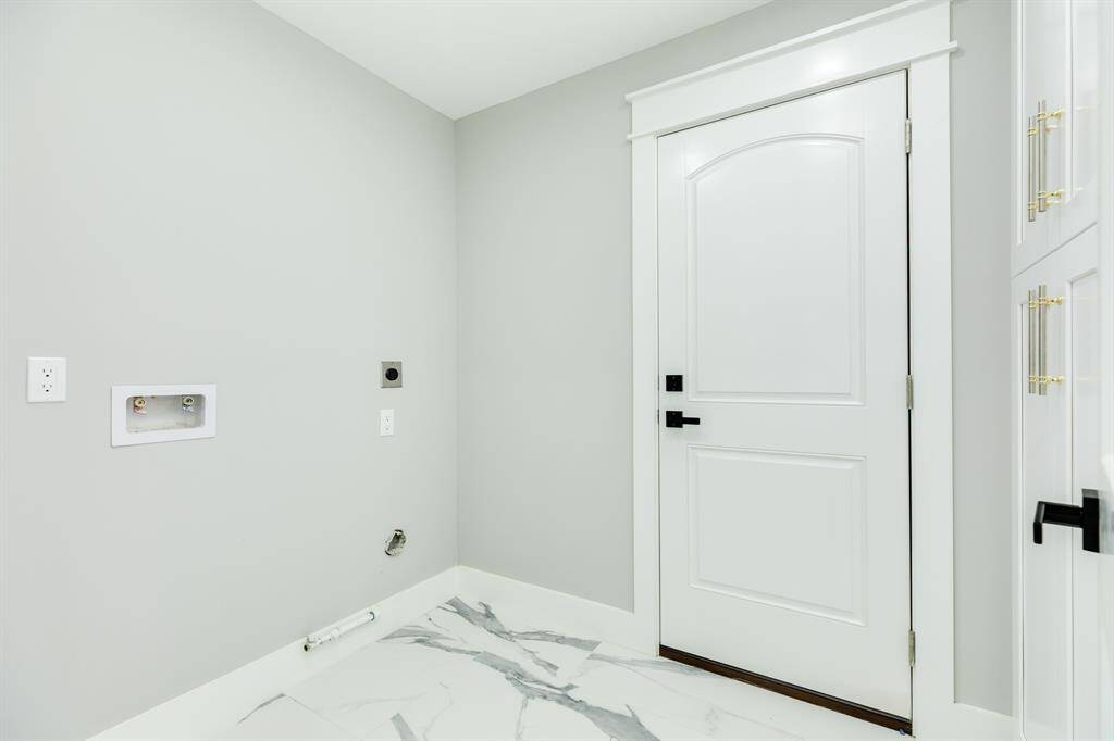 Laundry room off kitchen. Storage or pantry cabinets to the right.
