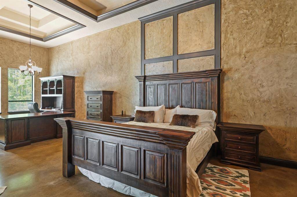 Spacious primary bedroom featuring elegant wood furnishings, a cozy atmosphere, and abundant natural light, perfect for relaxation and comfort.