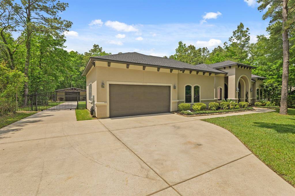 Elegant driveway entrance to the stunning home at 11058 Crawford Circle, Montgomery, TX, nestled in a serene, wooded setting.