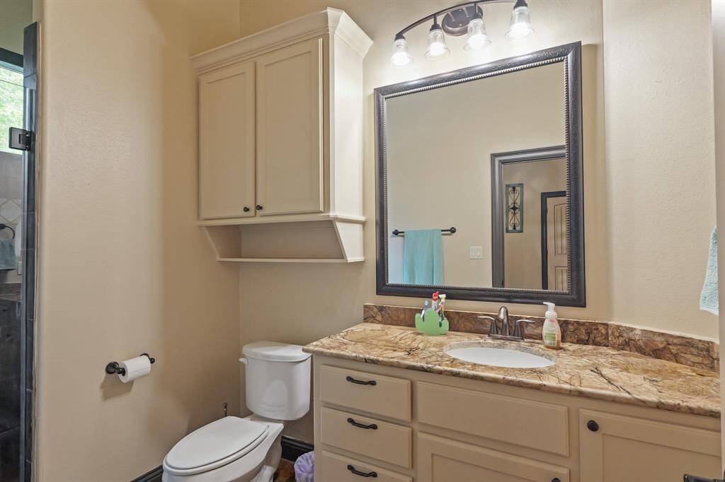 Convenient en suite bathroom with a sleek stand-up shower for the secondary bedroom.