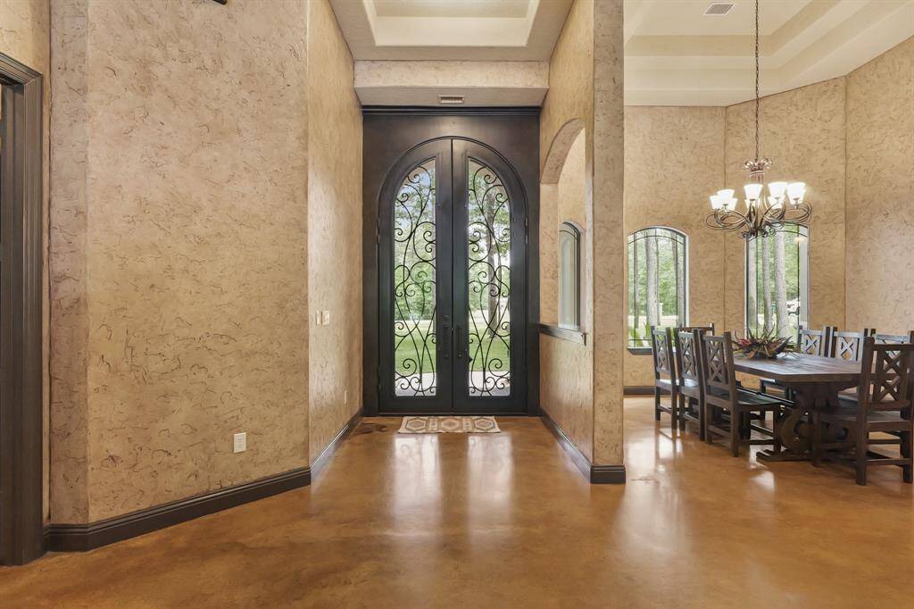 Welcome to the elegant foyer of 11058 Crawford Circle, Montgomery, TX. Featuring a grand entrance with intricate ironwork doors and rich, textured walls, this inviting space sets the tone for sophisticated living.