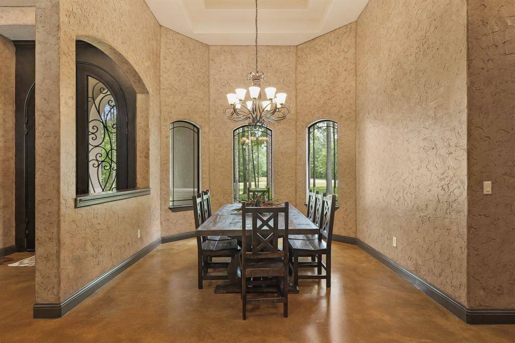 Elegant formal dining room with textured walls, large windows for natural light, and a sophisticated chandelier. Perfect for entertaining.