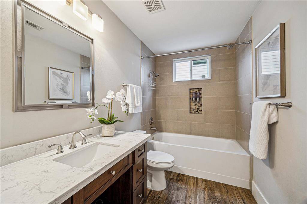 The full bathroom on the first floor is conveniently located between the two rooms and includes a fullytiled shower/tub combo and vanity storage.