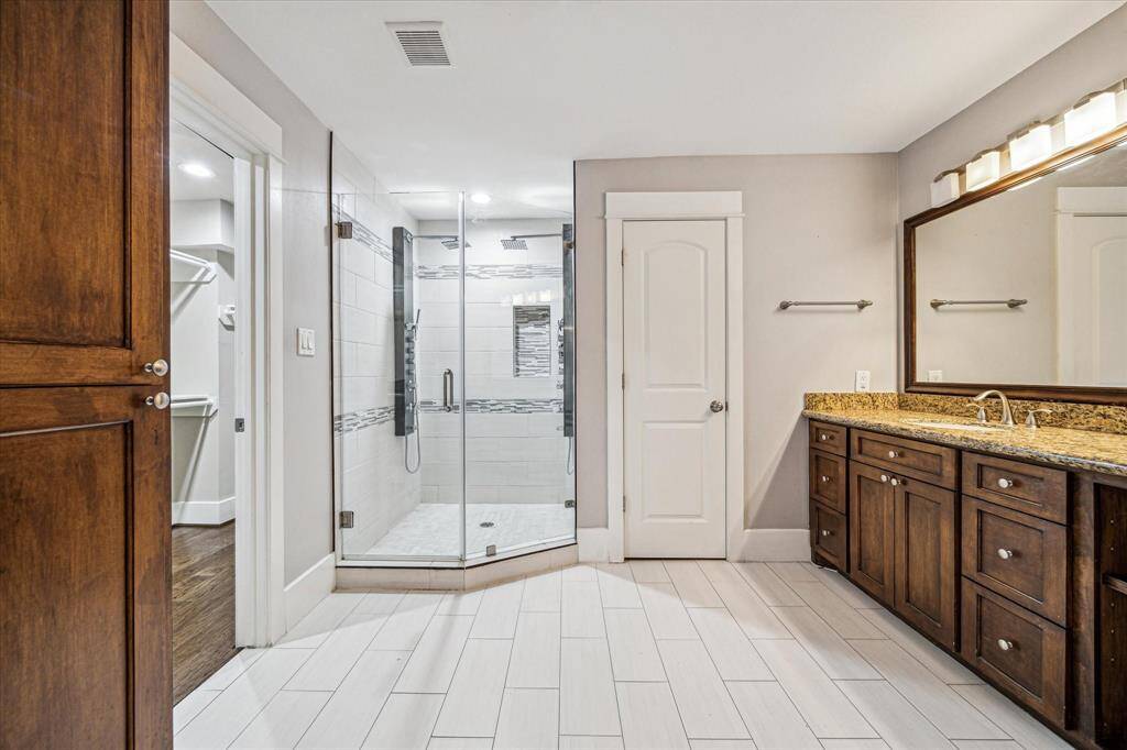 Through French doors is the primary bathroom with double sinks, a separate water closet, and an incredible jettedshower.