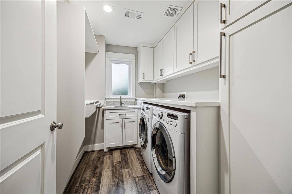 The laundry room includes counter space for folding, storage space, a sink, window for natural light, and even the space to hang dry clothes.