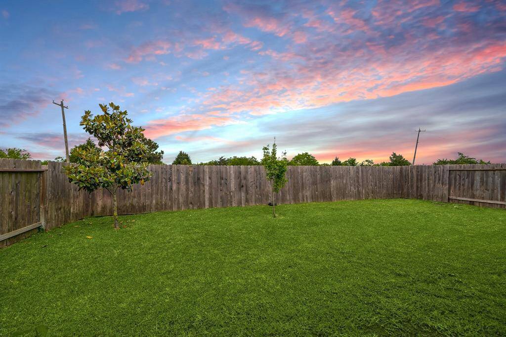 View of the large, privately fenced backyard from the covered back porch!  As you can see, no back neighbors!