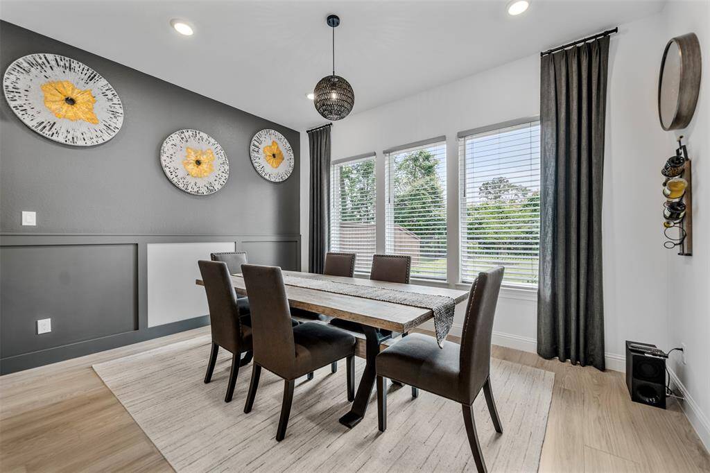 The dining room boasts a new chandelier and large windows overlooking the peaceful yard.
