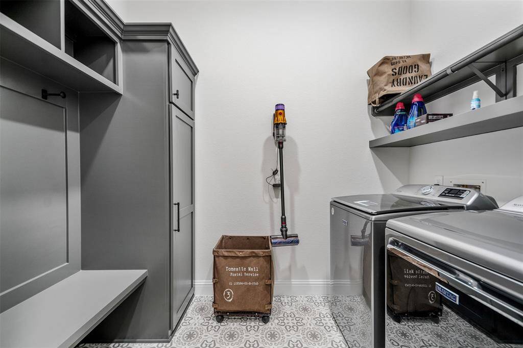 The spacious laundry room is both practical and stylish, featuring built-in shoe and coat racks that keep everything organized and easily accessible. Modern tile flooring adds a sleek touch, and a new sliding barn door enhances the room’s charm while providing easy access. The generous space ensures plenty of room for sorting, folding, and managing household tasks with ease.