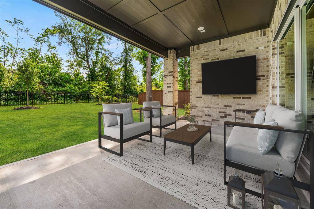 The covered patio is the perfect outdoor retreat, wired for a television so you can enjoy your favorite shows or sports games in comfort. Overlooking the expansive yard, it provides an ideal space for relaxing, entertaining, or dining al fresco, all while enjoying the serene surroundings.