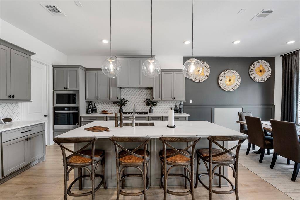 The open kitchen allows for large family gatherings with a breakfast bar, large island and stainless steel appliances.