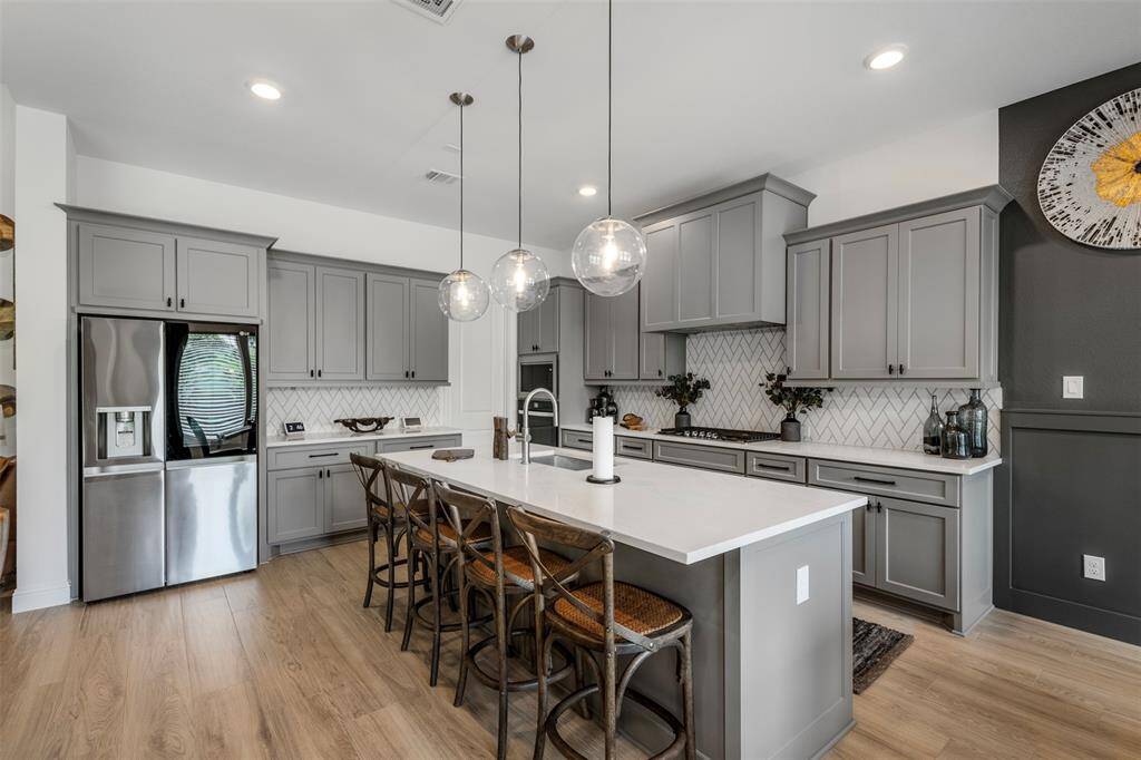 Recessed lighting and modern light fixtures elevate the space making it the perfect kitchen for hosting holidays and gatherings.