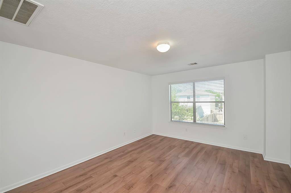 The expansive game room with sleek LVP flooring, providing both durability and style. Window treatments to offering privacy when needed. Additionally, a spacious storage closet ensures that belongings are neatly tucked away.