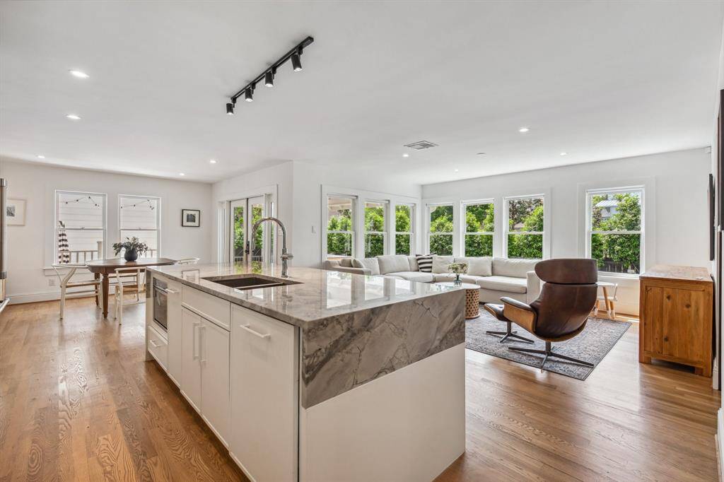 The massive waterfall island boasts a Signature Hardware double undermount sink and a built-in microwave drawer and cabinet-front dishwasher by Thermador.