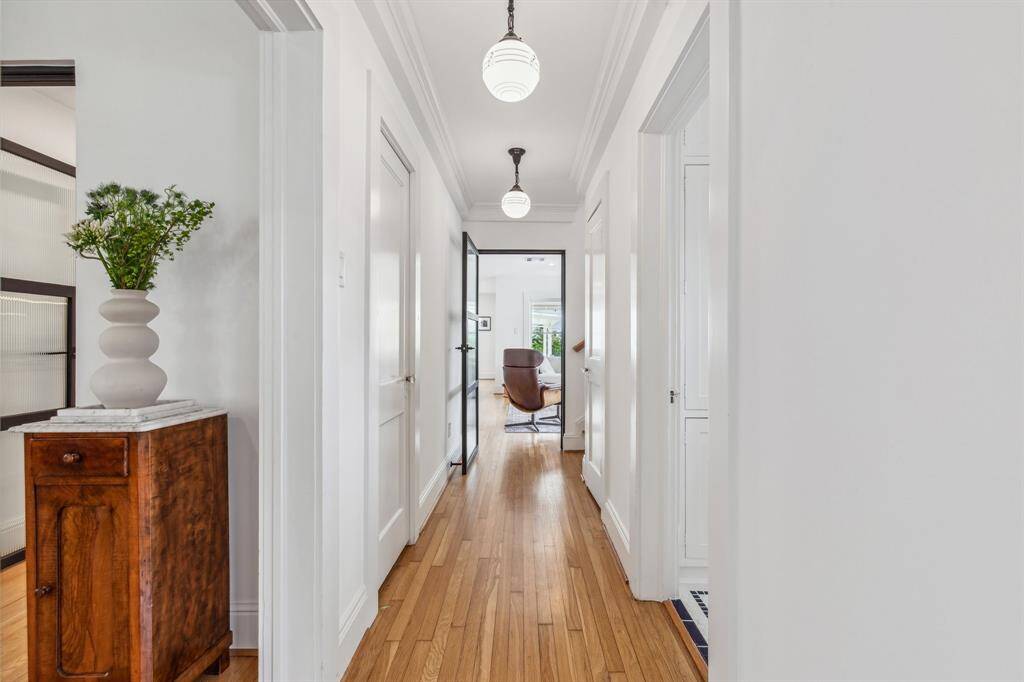 The beautifully preserved first-floor guest bathroom boasts a pedestal sink, built-in medicine and linen cabinets, and a large tub/shower surrounded by beadboard wainscoting and classic blue and white tile.