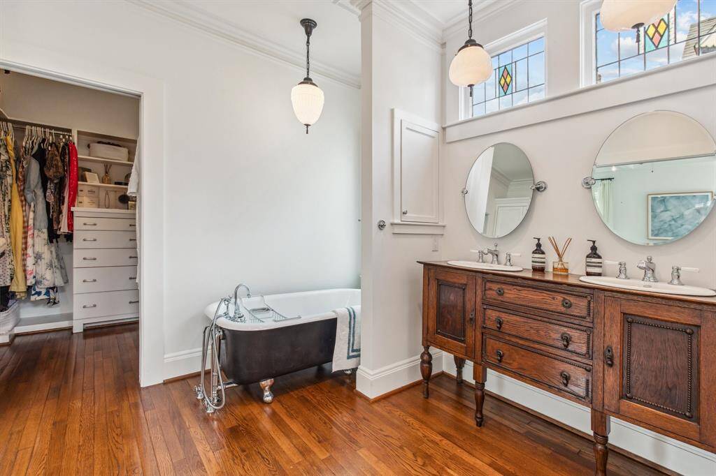 Sleep soundly in the primary suite filled with coffered ceilings, antique lighting, a ceiling fan and large windows on two exposures.