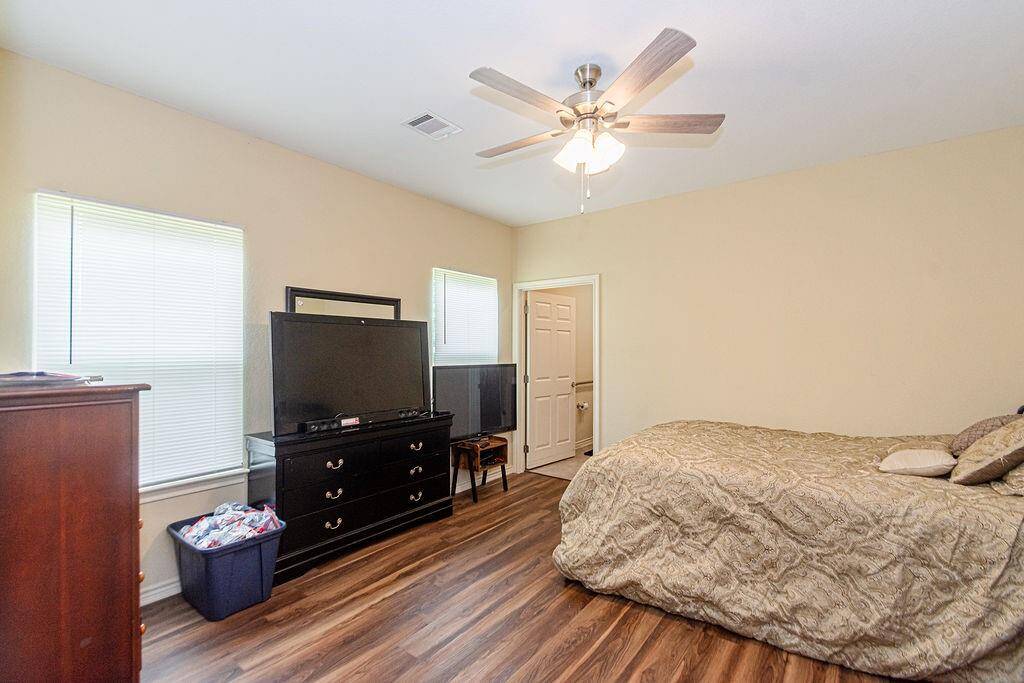 Large primary bedroom with two windows with tons of light.