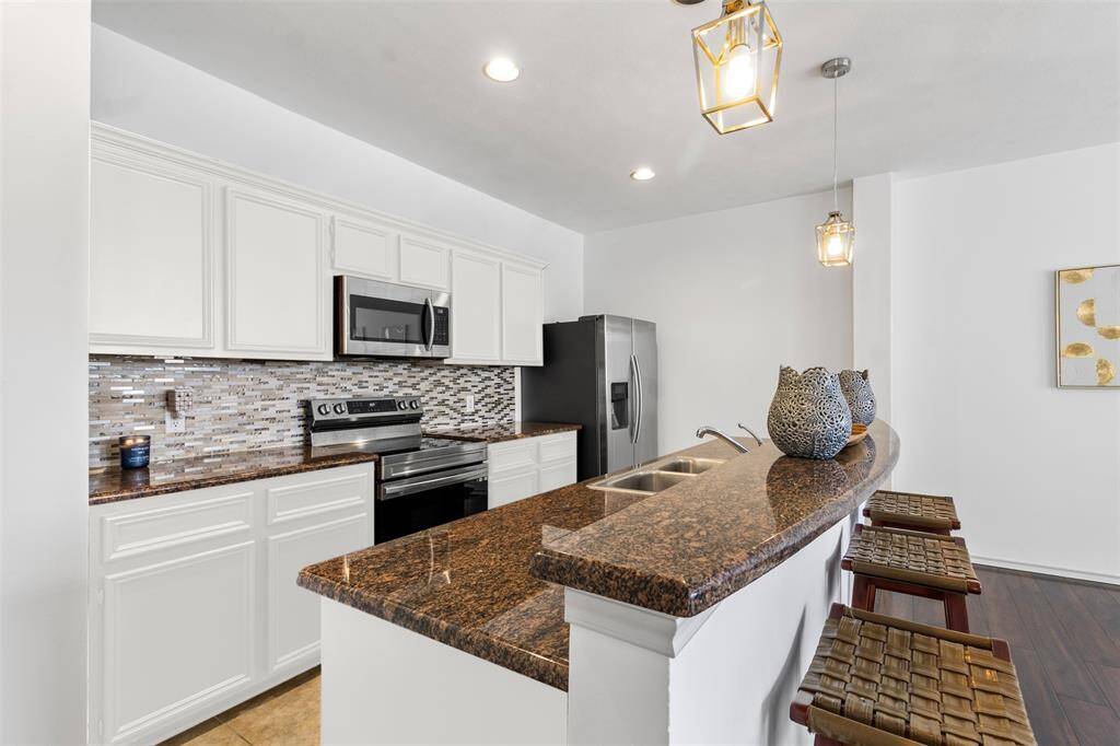 Step into a contemporary culinary haven where the kitchen effortlessly flows into the dining area, creating a harmonious space designed for both functionality and style. The kitchen features sleek, modern cabinetry with a sophisticated finish, complemented by a large island that serves as both a prep space and a casual eating spot.