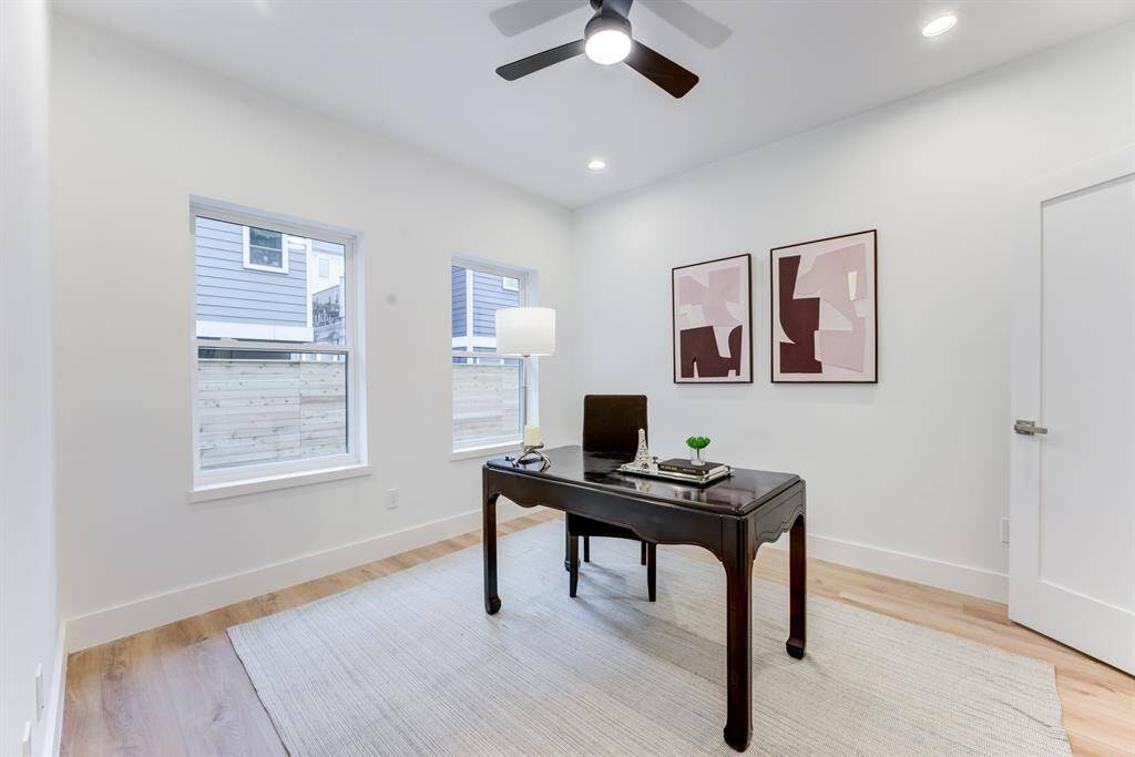 First floor bedroom with en-suite bathroom, ceiling fan, recessed lighting, and luxury vinyl plank flooring.