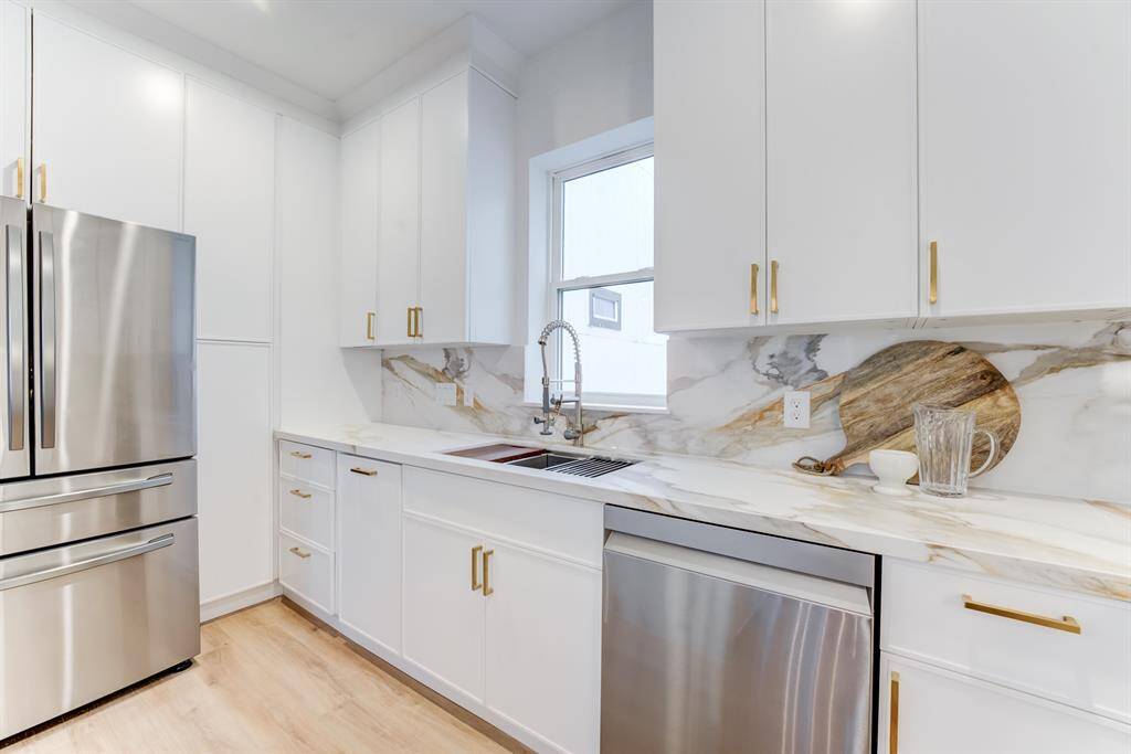 The home includes stainless steel  appliances, pantry storage, and  stunning white cabinetry and  drawers for a timeless kitchen  space.